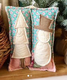 two decorative pillows sitting on top of a wooden shelf