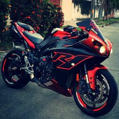 a red and black motorcycle parked on the street