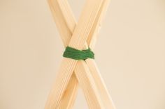 two wooden sticks with green string tied to them