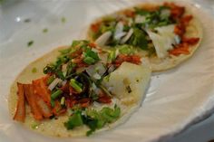 two tortillas with vegetables on them sitting on a plate