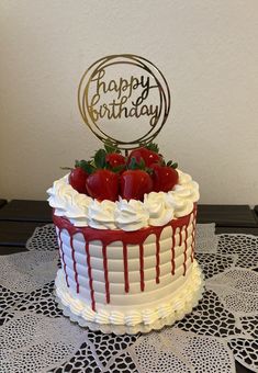 a birthday cake with white frosting and strawberries on top