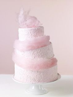 there is a three tiered cake with pink frosting on the top and bottom