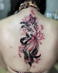 the back of a woman's neck with an intricate tattoo design on her lower back