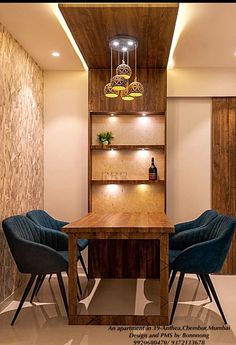 a dining room table with blue chairs and a wooden bookcase in the corner next to it