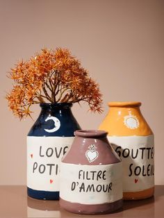 three vases with flowers in them sitting on a table