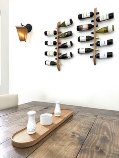 a wooden table topped with bottles of wine and two vases on top of it