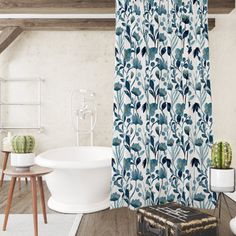 a bath tub sitting next to a white sink under a window covered in blue leaves