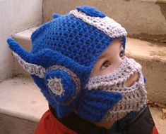 a young boy wearing a crocheted viking helmet