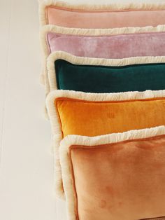 four different colored pillows stacked on top of each other