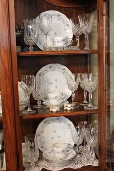 a china cabinet with dishes and glasses on it