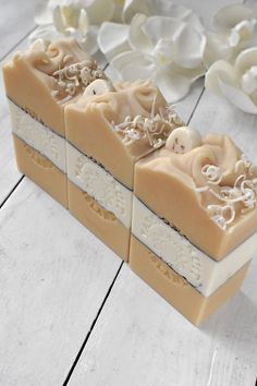 three bars of soap sitting next to each other on top of a white wooden table