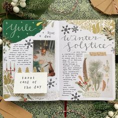 an open book with pictures and words on the pages, surrounded by christmas decorations including pine cones