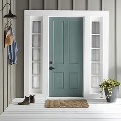 a blue front door with two shelves on either side and a potted plant next to it