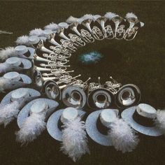 an assortment of hats and feathers are arranged on the ground