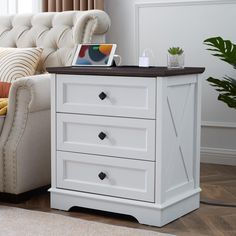 a living room with a couch, chair and white chest of drawers on the floor