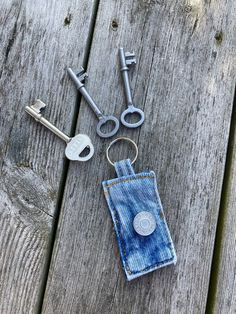 the keys are laying next to each other on the wooden table with some keychains