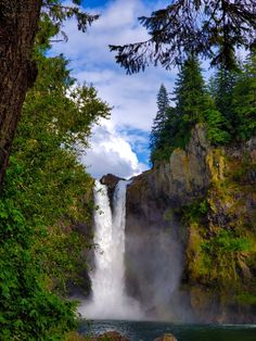 a large waterfall surrounded by lush green trees