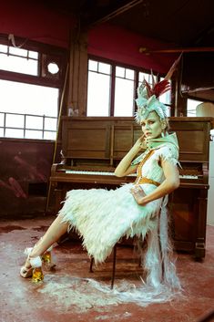 a woman sitting on top of a chair next to a piano