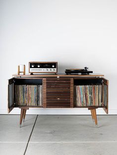 an old record player is sitting on top of a cabinet