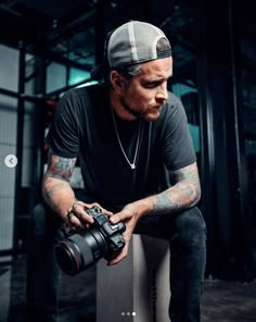 a man sitting on top of a white box holding a camera