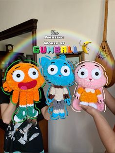 three stuffed animals are being held up in front of a mirror with a rainbow behind them