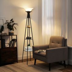 a living room with a chair, lamp and bookshelf on the floor in front of a window