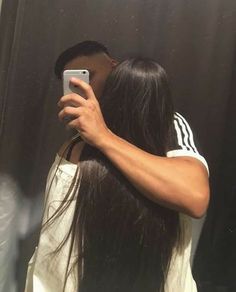 a man taking a selfie in front of a mirror with his hair back to the camera