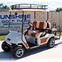 a white and brown golf cart parked in front of a building