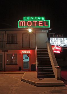 the entrance to a motel at night with stairs leading up to it's door