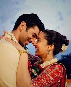 a man and woman embracing each other with the sky in the back ground behind them