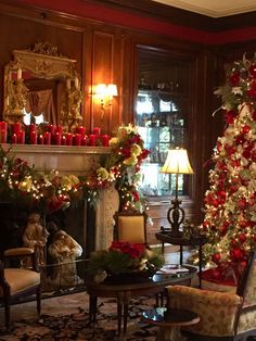 a living room decorated for christmas with candles and holiday decorations on the fireplace mantel