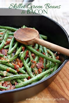 green beans and bacon in a skillet with a wooden spoon