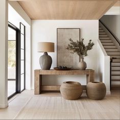 a living room with two vases and a lamp on the table next to it