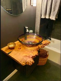 a bathroom sink sitting on top of a wooden counter next to a bath tub and shower