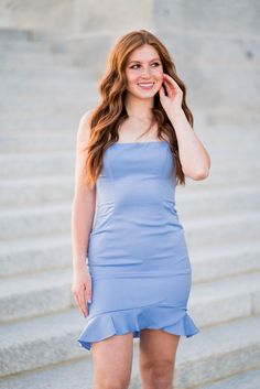 A model in a simple fitted dress features spaghetti straps and a lace-up back with ruffle hemline.