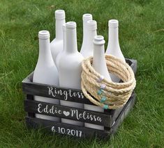 a crate filled with white bottles sitting on top of green grass