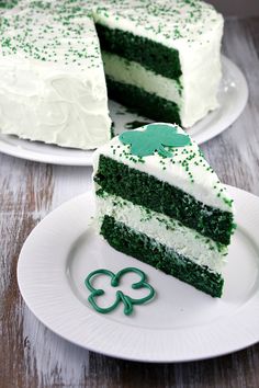 a slice of green cake on a white plate with shamrock decorations and a clover decoration