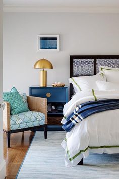 a bedroom with white bedding and blue accents