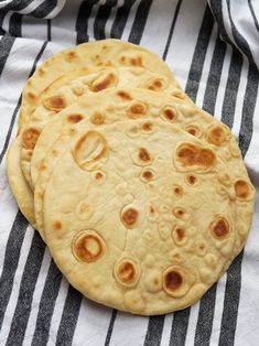 three flatbreads sitting on top of a black and white striped table cloth with the words, quick flatbreads no yeast / no yogurt