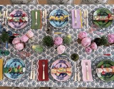 the table is set with plates and place settings