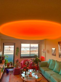 a living room filled with furniture and a large round light fixture hanging from the ceiling