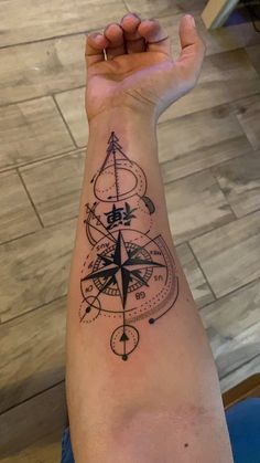 a man's arm with a compass tattoo on it