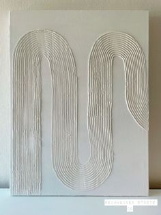 the letter u is made out of white paint and has wavy lines on it's surface