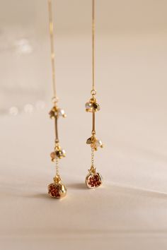 Dainty crystal-studded fruits on a minimal drop thread design, adorned with high-shine polished crystals, mini pearls and golden beads that catches and reflects the sun beautifully. Made with 14k gold plated accessories. Threader comes with silicone stopper. Available in 2 variations: Pomegranate & Pear. As all items are handmade, there may be imperfections, such as slight differences in colour and measurements.  ------- - SHIPPING INFO -   A tracking number will be provided for all orders upon Asian Earrings, Sun Jewelry, Polished Crystals, 14k Gold Plated Jewelry, Droplet Earrings, Thread Design, Golden Beads, Dangle Earrings Gold, Asian Jewelry