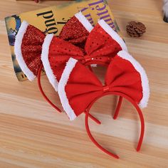 three red and white santa hats on top of a wooden table