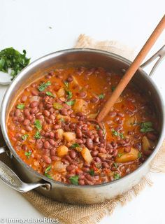 a pot filled with beans and vegetables on top of a table