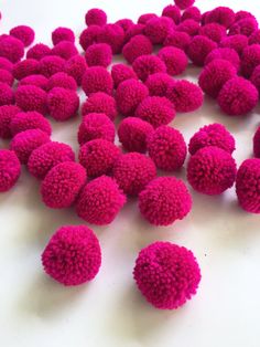 a pile of pink pom - poms sitting on top of a white table