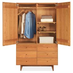 an open wooden wardrobe with clothes hanging on it