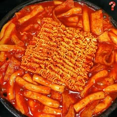 a pan filled with pasta and sauce on top of a stove