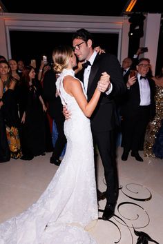 a bride and groom sharing a dance at their wedding reception in front of an audience